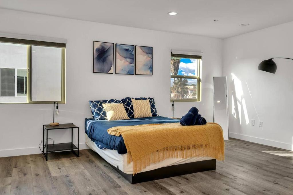 洛杉矶Wonderful 3 Bedroom Home Perfect for Getaway的一间卧室配有一张带蓝色毯子的床和两个窗户。