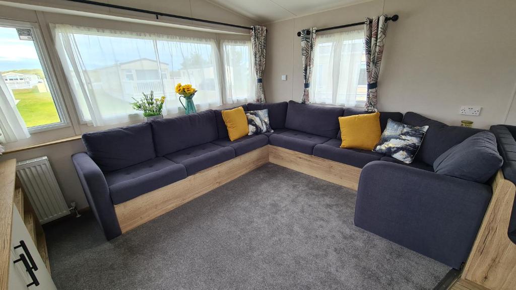 洛西茅斯Madaisy的客厅配有蓝色的沙发和黄色的枕头。