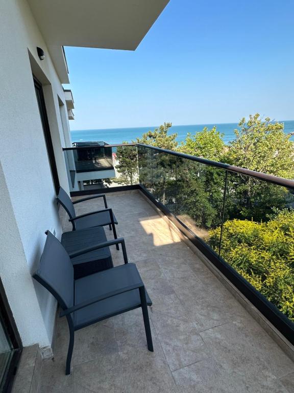 艾福雷诺德FORREST Villa的阳台配有椅子,享有海景。