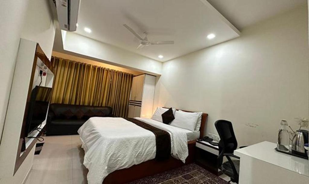 KharadiFabHotel Prime Finesse的配有一张床和一把椅子的酒店客房