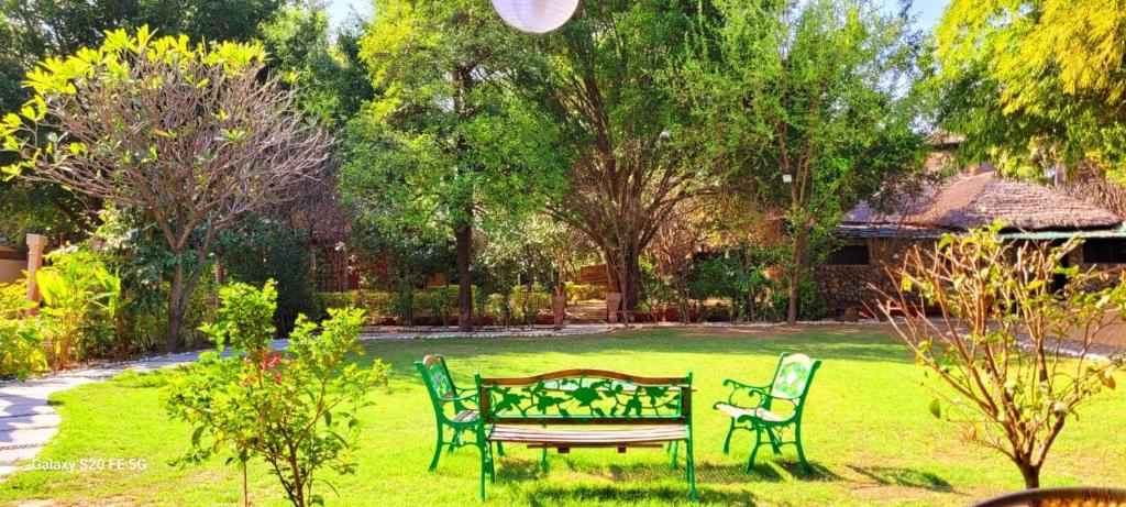 BelparāoLohagarh Corbett Resort的草地上带长椅的公园