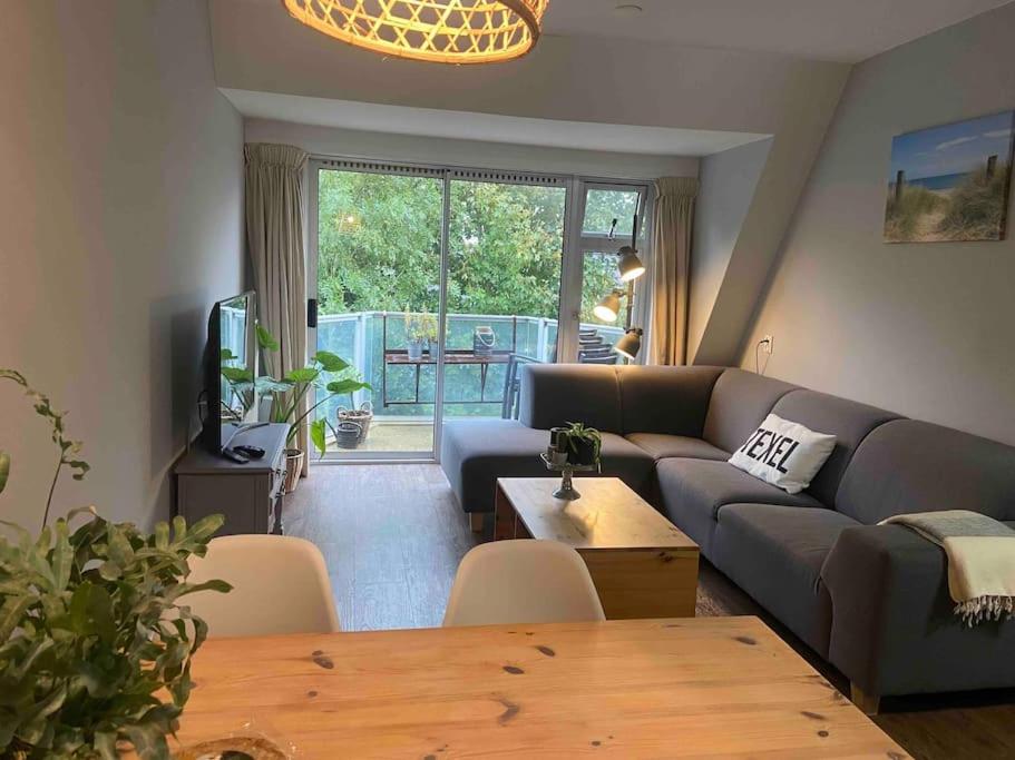 德科赫Heerlijk appartement op Texel vlakbij bos en zee.的客厅配有沙发和桌子