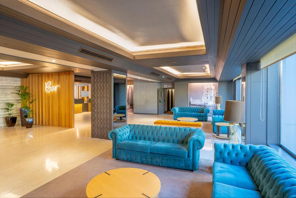 波尔图波尔图-图尔乐酒店的大堂设有蓝色的沙发和桌子