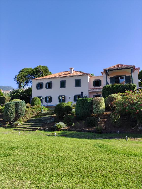 丰沙尔Quinta São Gonçalo的一座带草地庭院的大型白色房屋