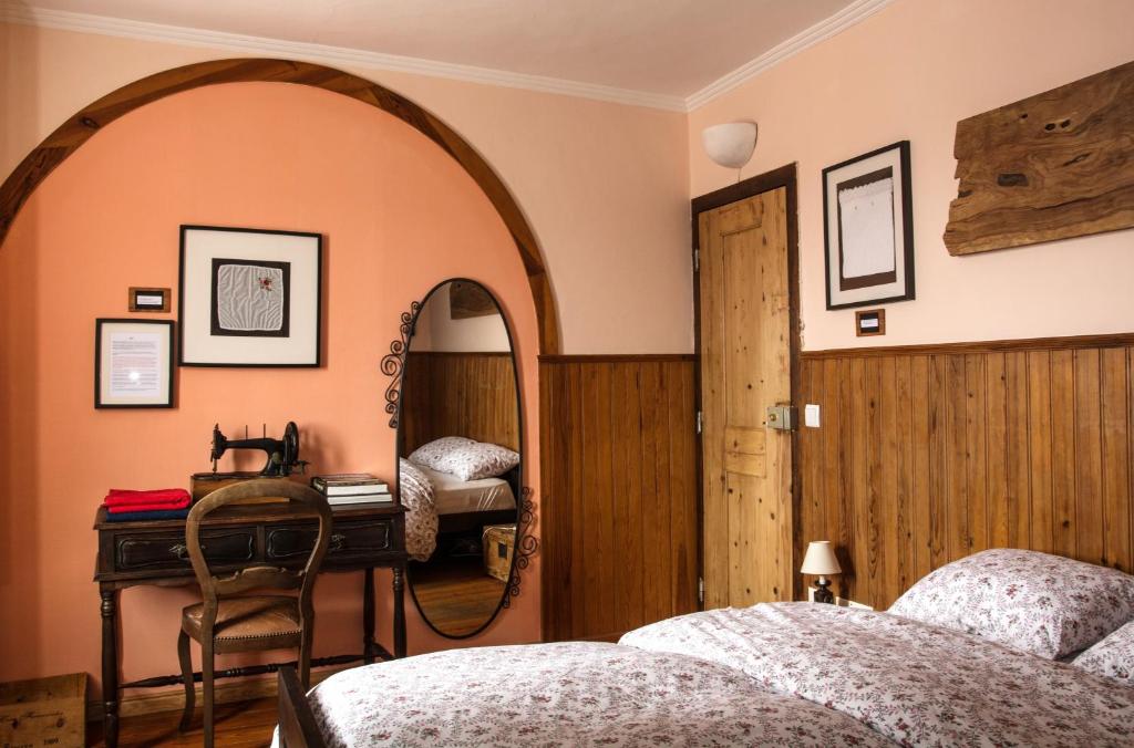 辛特拉辛特拉小型旅馆的一间卧室配有两张床、镜子和一张书桌