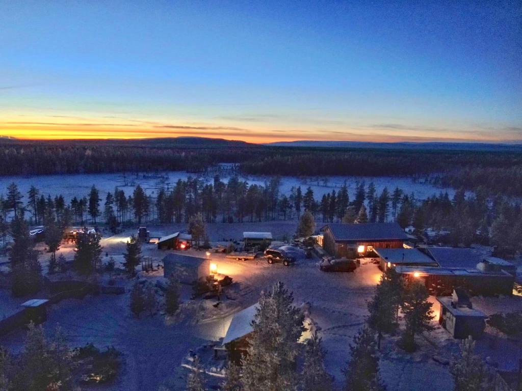 SörsjönOffroadcamp的日落时分在雪中享有小屋的空中景致