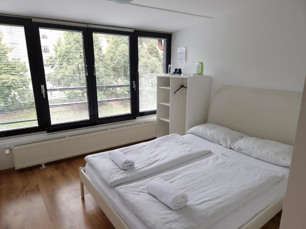 卢布尔雅那莫斯特旅馆的卧室设有2张白色的床和大窗户