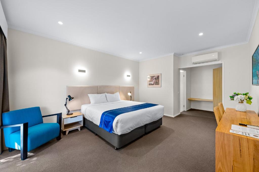 Rowville罗维尔国际酒店的酒店客房,配有一张床和一张蓝色椅子