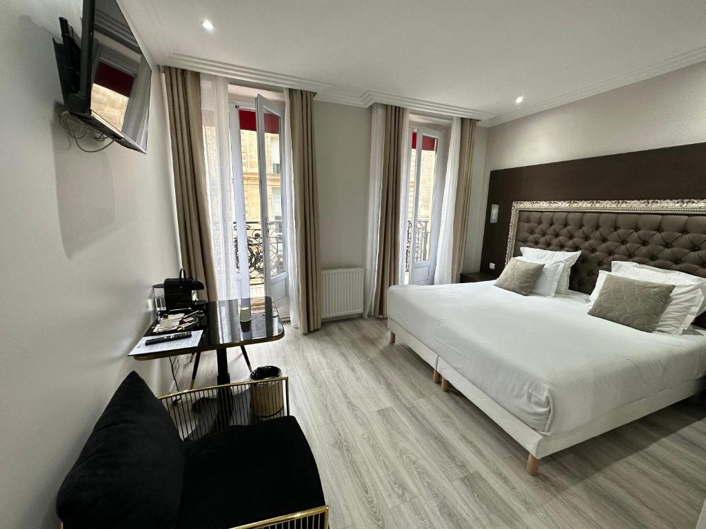 巴黎Hotel Riviera Renovated的卧室配有一张白色大床和电视。
