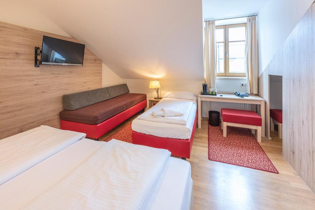 慕尼黑艾德酒店的客房设有两张床、一张桌子和一台电视机。