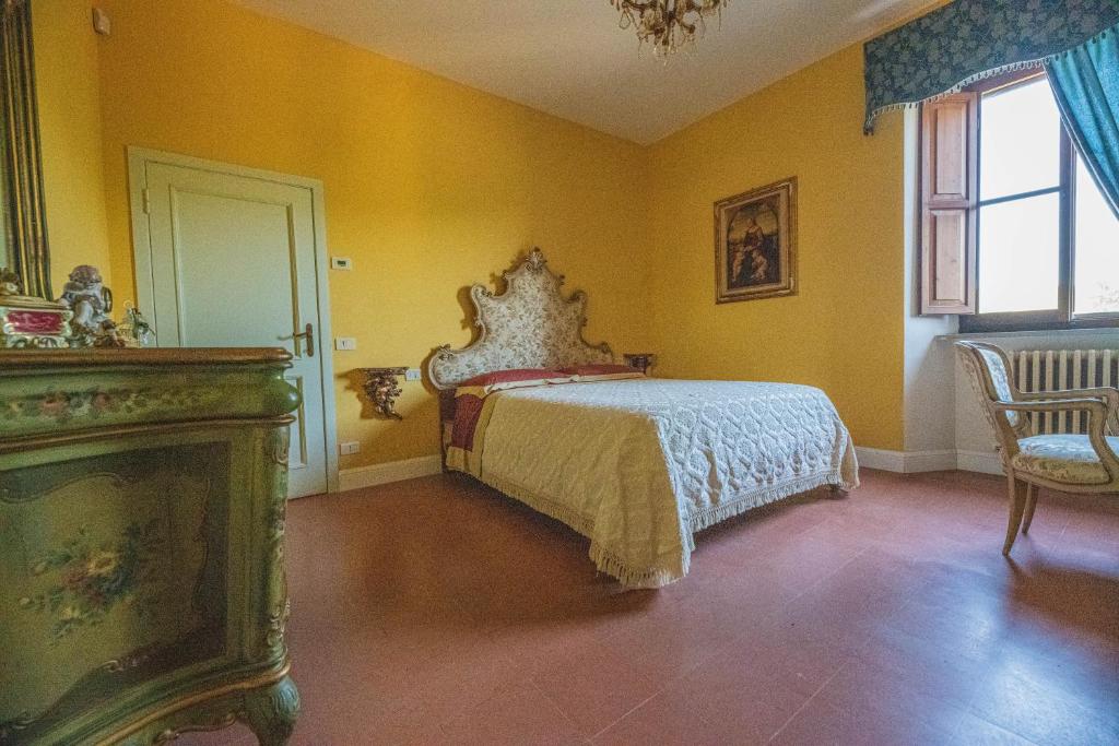 乌尔比诺Suite con Bagno in villa esclusiva - Urbino的卧室配有一张床铺,位于一个黄色墙壁的房间