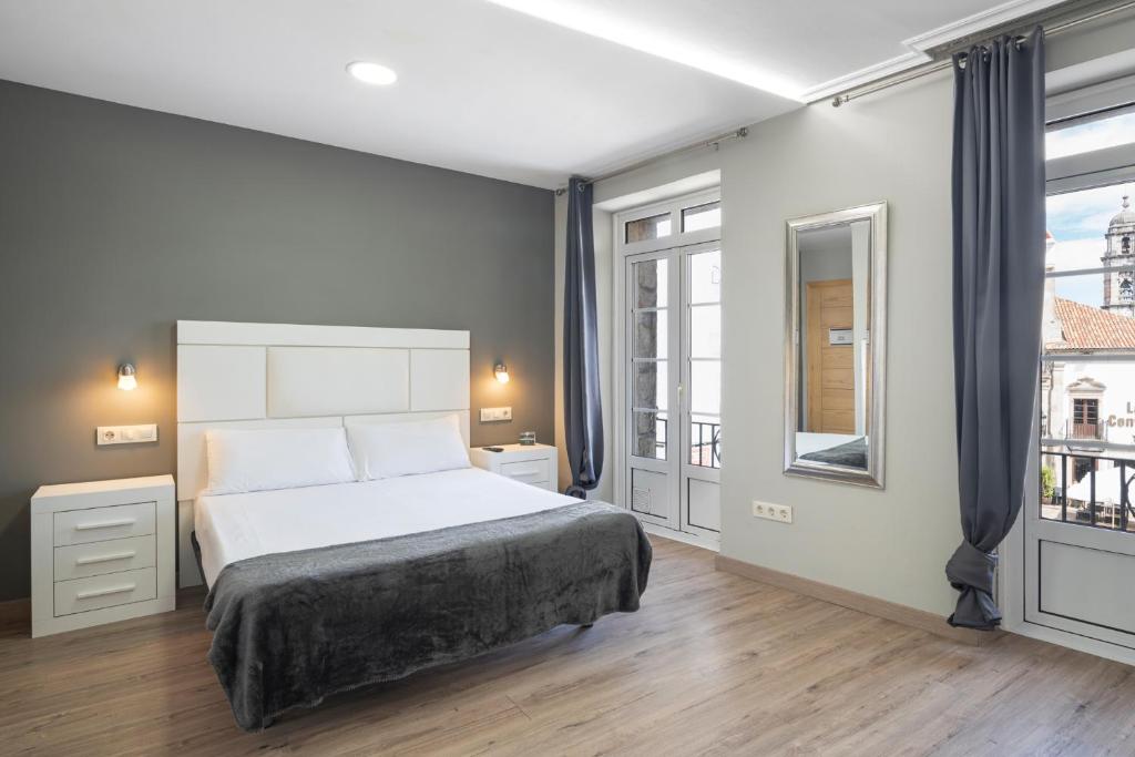 维戈Hotel Alda Puerta Del Sol的一间卧室设有一张床和一个大窗户