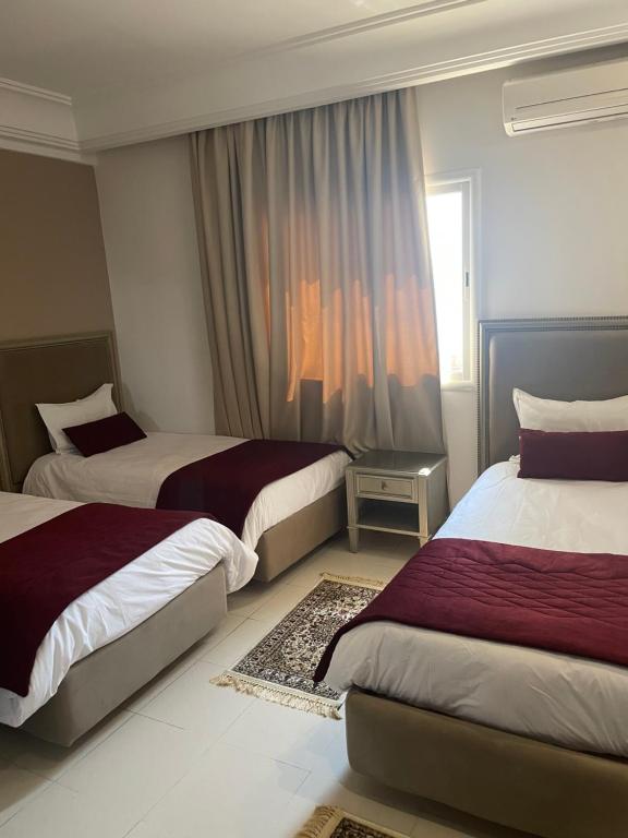 斯法克斯Pacha hotel的酒店客房设有两张床和窗户。