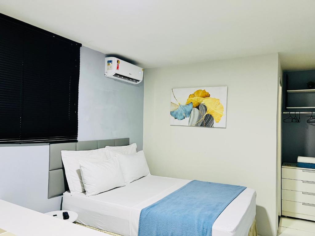 圣路易斯Edifício Creta的卧室配有一张床,墙上挂有绘画作品