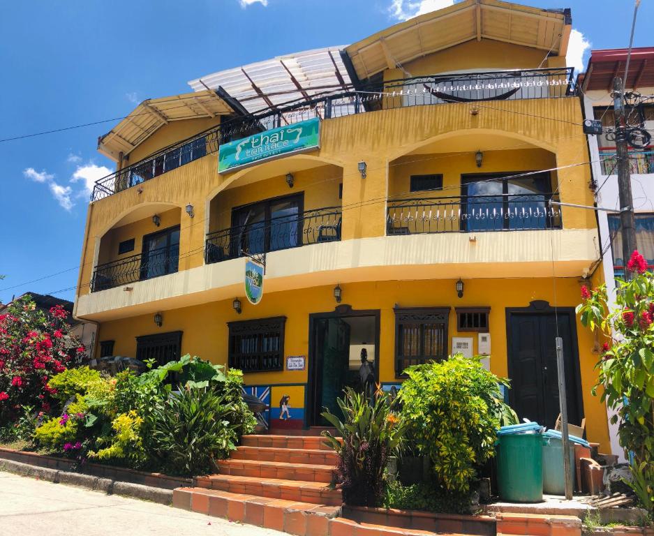 瓜塔佩Lake View Hostel的前面有楼梯的黄色建筑