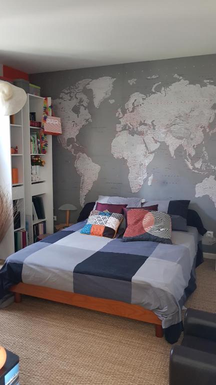 VauréalChez Laurence & RV的卧室配有一张大床,墙上挂有地图