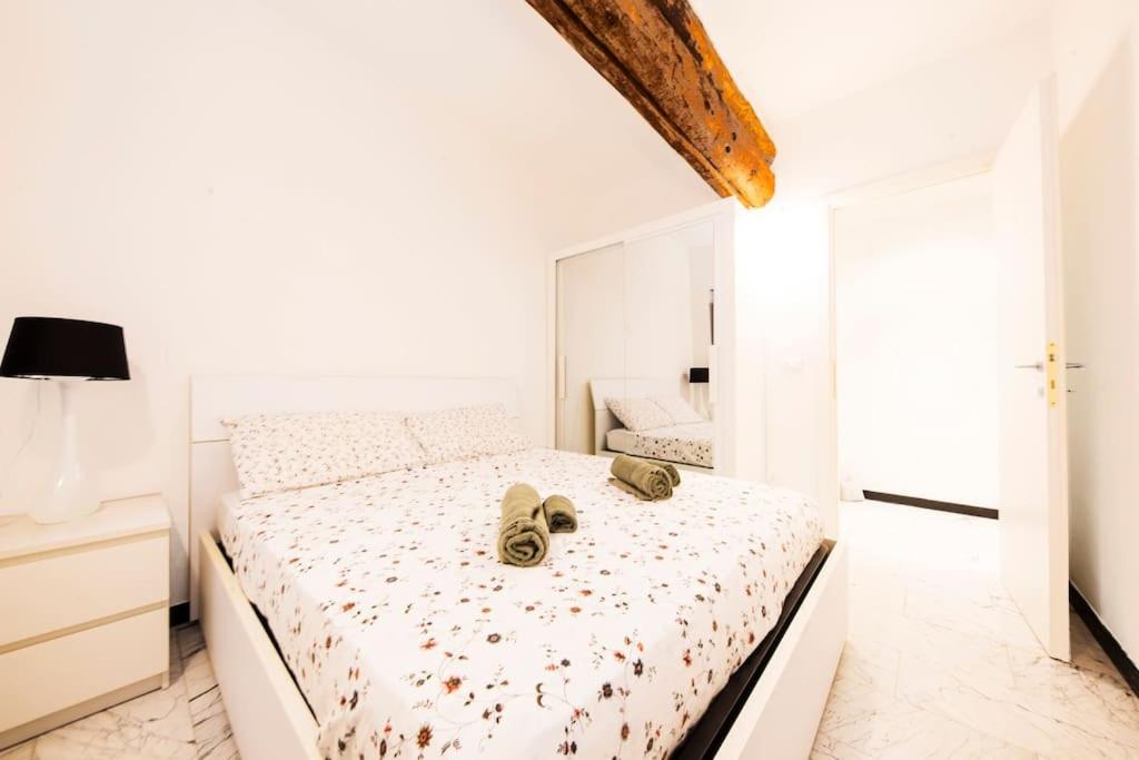 热那亚Appartamento La Città Vecchia的白色卧室,床上有鞋