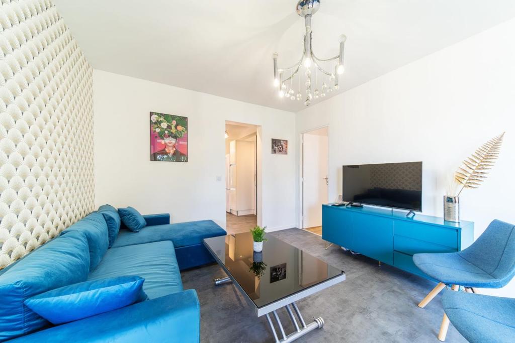 布隆Appartement spacieux 8 pers avec balcon Bron的客厅配有蓝色的沙发和电视