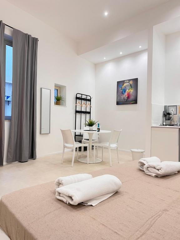 巴勒莫Valguarnera Studio Apartments的白色的客厅配有桌椅