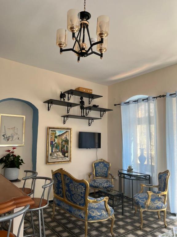耶路撒冷La Provençale的客厅配有椅子、桌子和吊灯。
