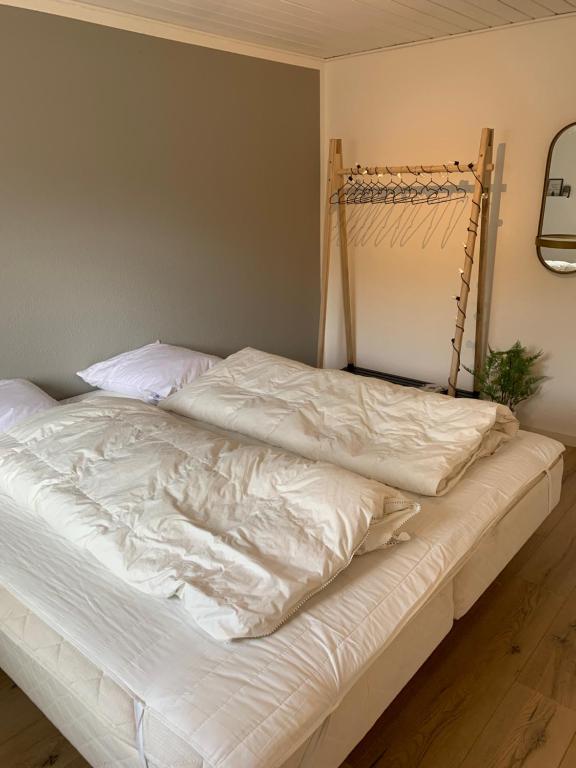 SundsHuset ved søen tæt på Herning og MCH og boxen 90 m2的卧室内一张带白色床单的未铺床
