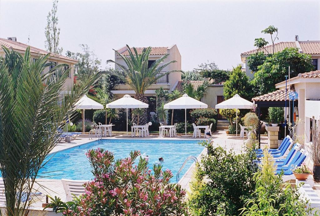 波利斯金牛座公寓式酒店的游泳池,带椅子和遮阳伞