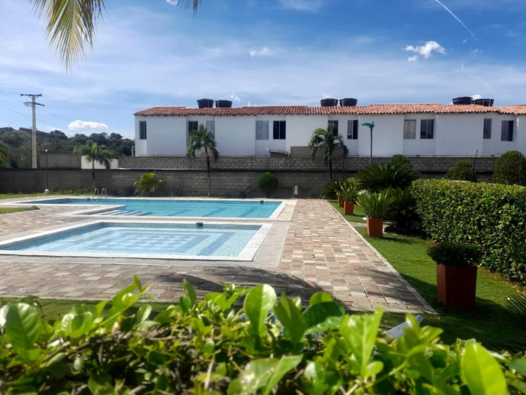库库塔CASA AMOBLADA EN CONJUNTO CERRADO的一座带游泳池和房子的别墅
