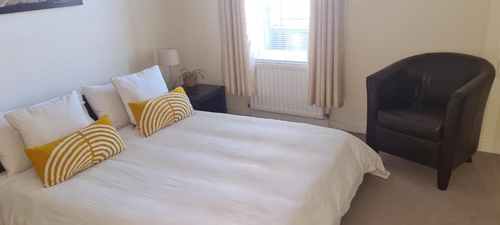 阿伯丁2 bed city centre executive apartment的卧室配有带枕头和椅子的白色床