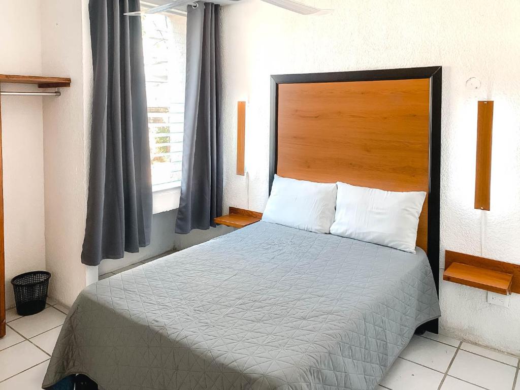 巴亚尔塔港Departamentos 1E的一间卧室配有一张大床和木制床头板