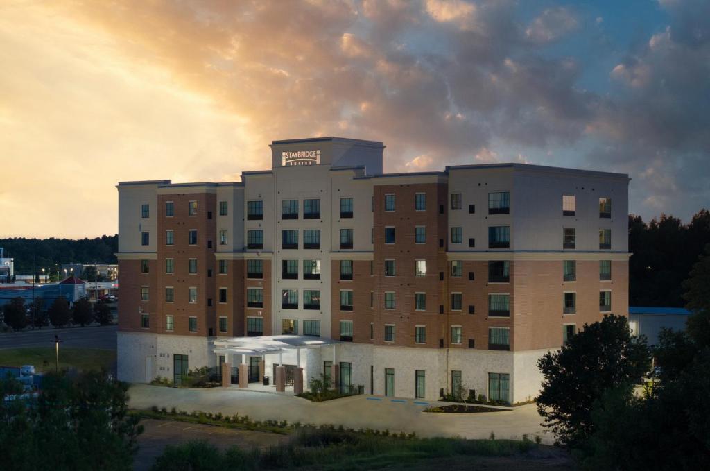 弗洛伍德Staybridge Suites - Flowood - NW Jackson, an IHG Hotel的一座大建筑,背景是日落