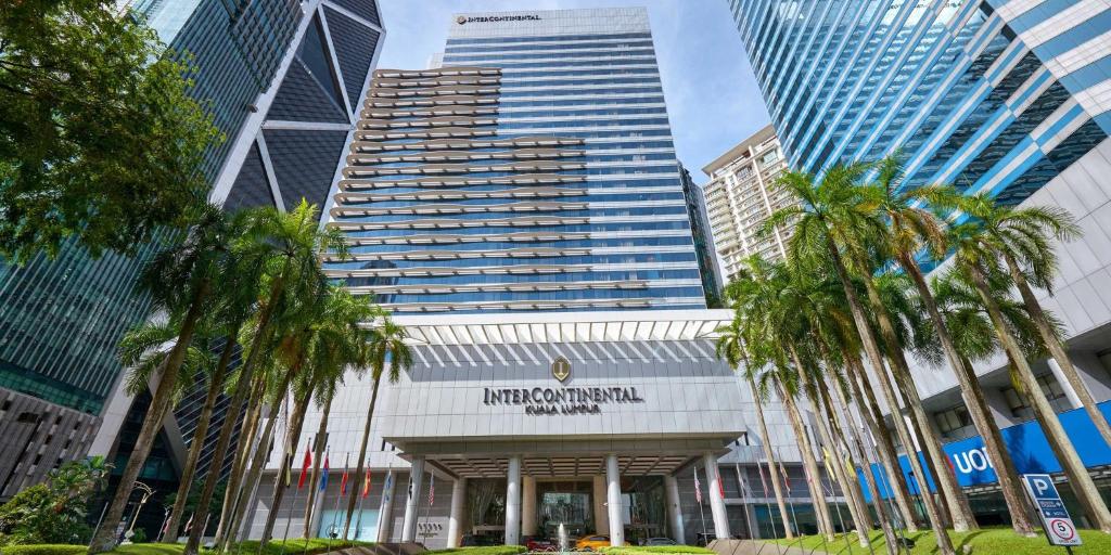 吉隆坡吉隆坡洲际酒店的一座棕榈树环绕的建筑,位于高楼前