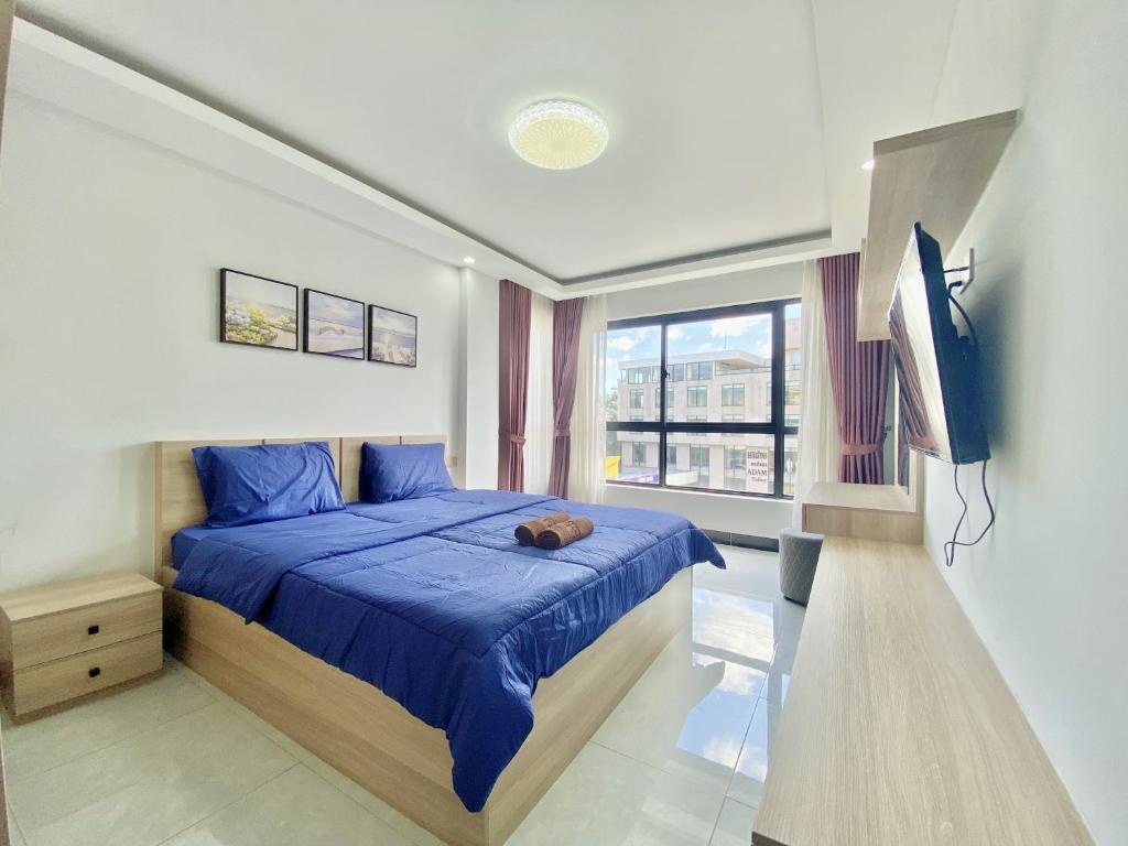 金边WH Chamkarmon Residence的一间卧室配有蓝色的床和电视