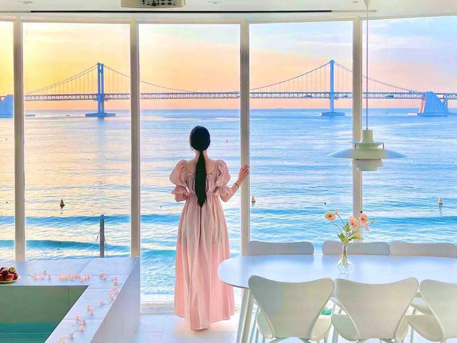 釜山Stay moment的穿着粉红色衣服的女人,看着大海