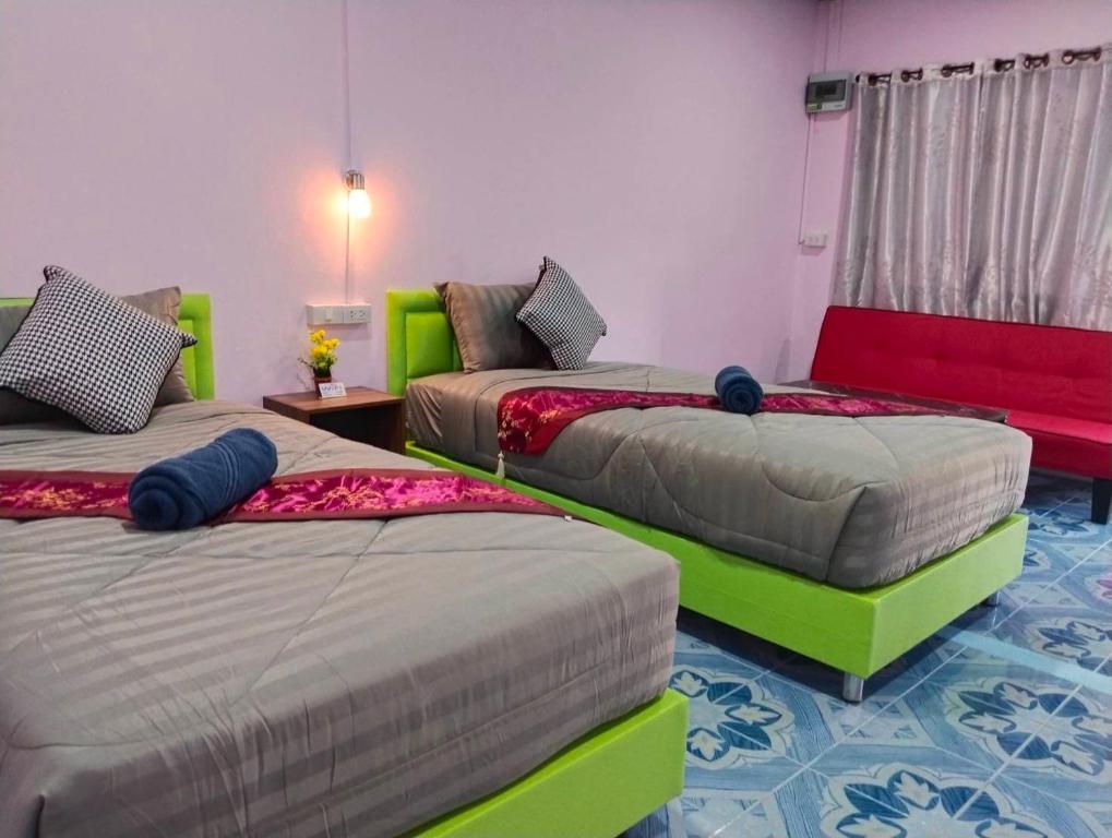 班拉克海滩SK Hometel Samui Airport的红色和绿色的客房内的三张床