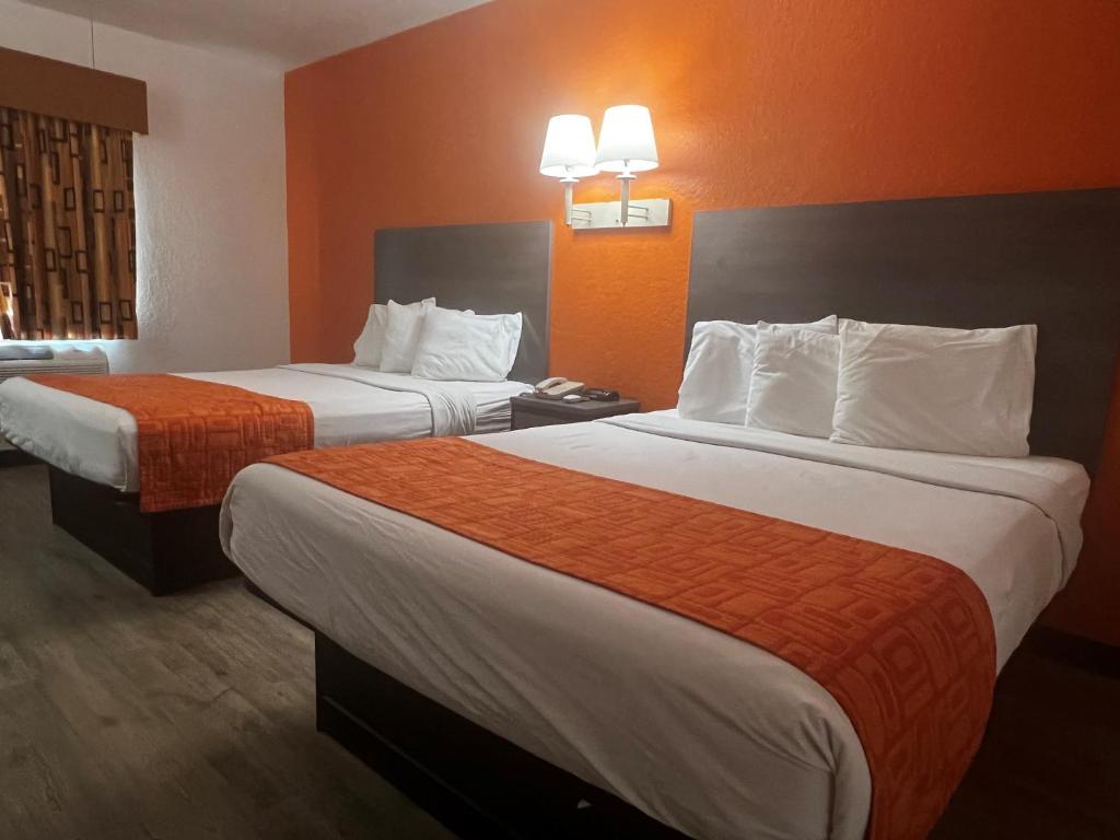 加尔维斯敦德克萨斯加尔维斯顿豪生国际快捷酒店的酒店客房,设有两张带橙色墙壁的床