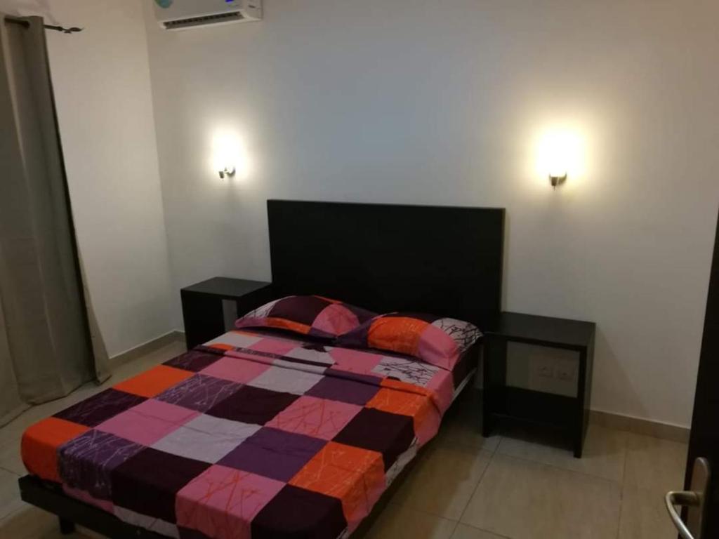 黑角Appartement coup de cœur的一间卧室配有一张带彩色毯子的床