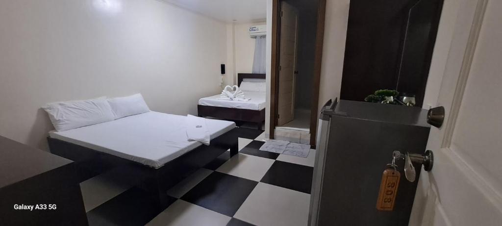 波尔多·格尼拉Bayside Exceel Hotel的客房设有两张床,铺有黑白的格子地板。