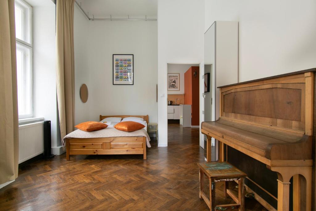 克拉科夫Apartments Studencka Street, Next to Planty Park的一间卧室配有一张床和一架钢琴