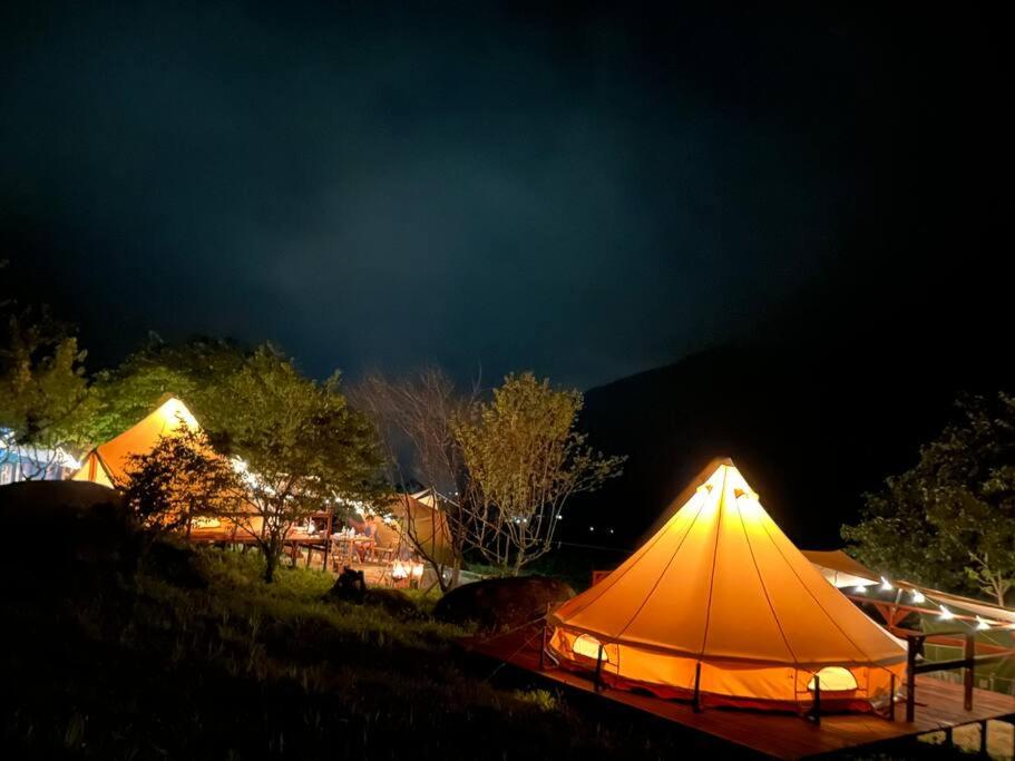 南木曾町ties Camp Ground Nagiso的一群帐篷在晚上在田野里