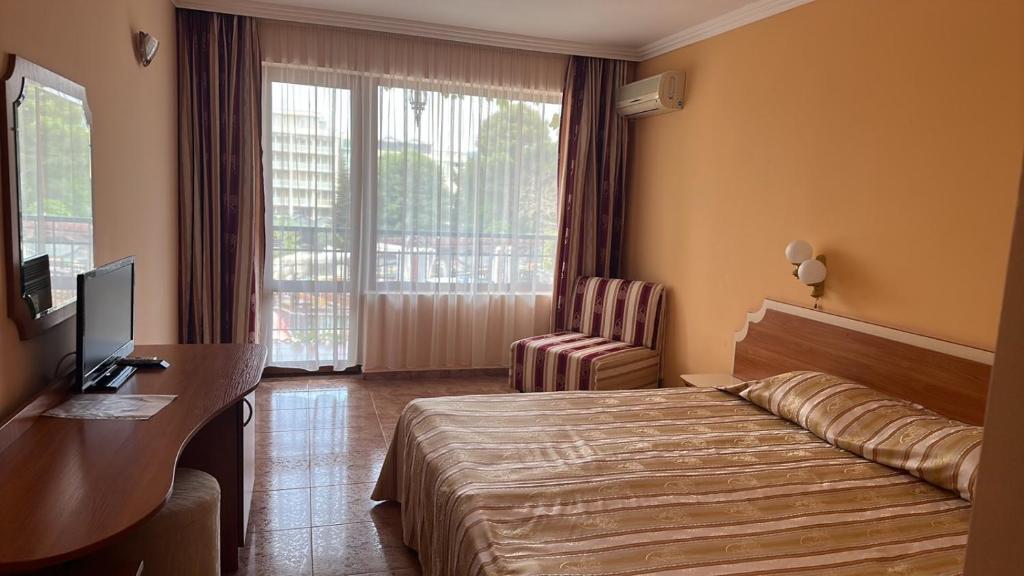 阳光海滩夹竹桃酒店和网球俱乐部的酒店客房配有一张床、一张书桌和一台电视。