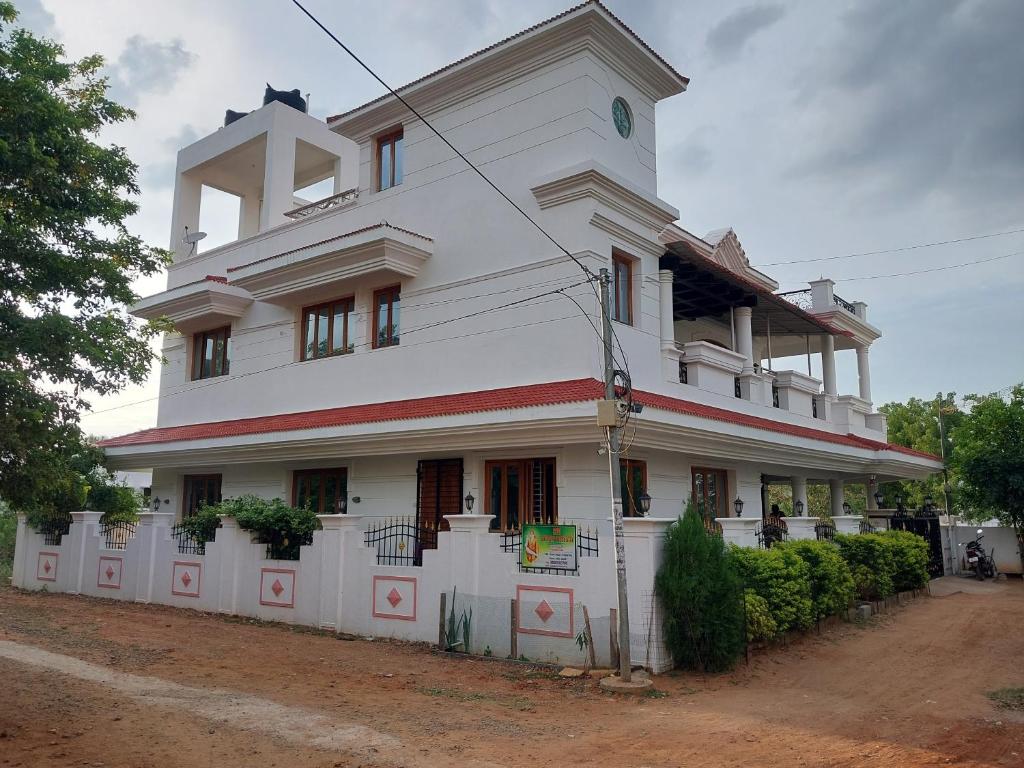 蒂鲁奇奇拉帕利Shri Sai Baba Homestay - EB Colony - Trichy的前面有栅栏的大白色建筑