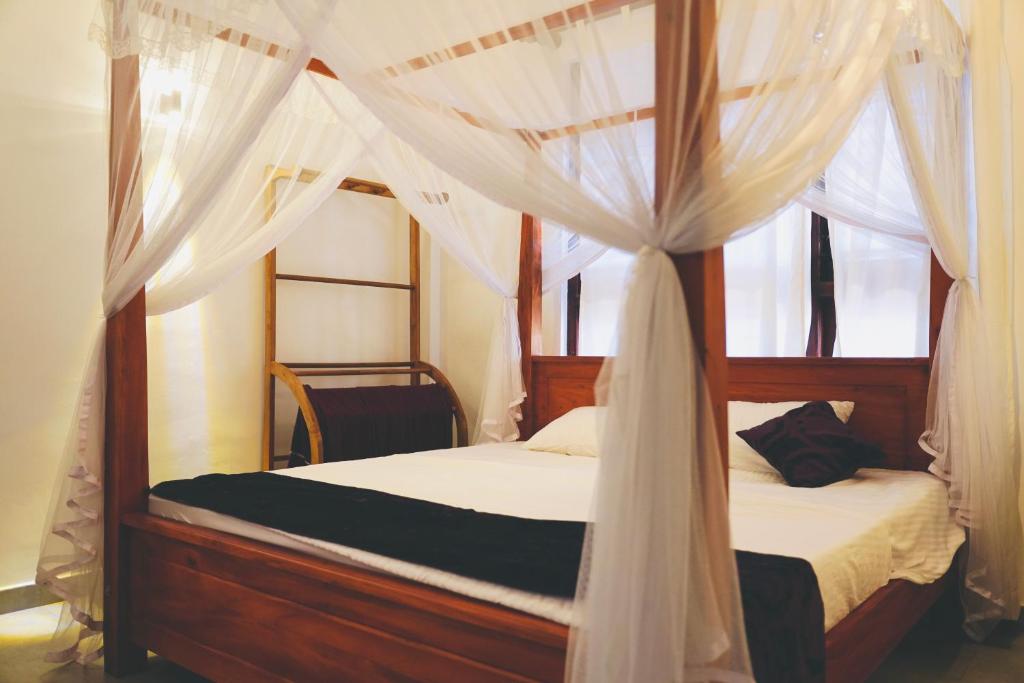 阿杭格默Soul Inn的卧室配有带白色窗帘的天蓬床