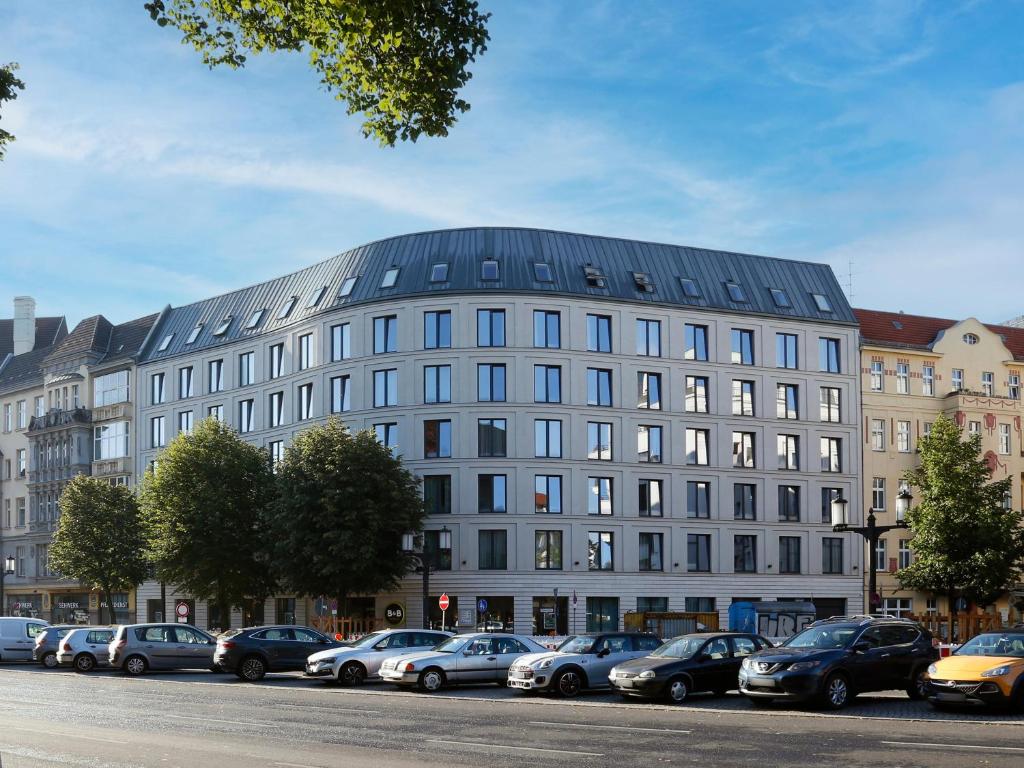 柏林柏林夏洛滕堡酒店的一座大型建筑,前面有汽车停放