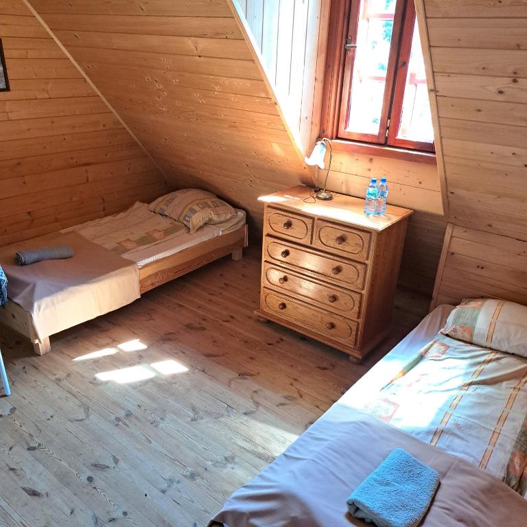 Dom Glówny的小木屋内一间卧室配有两张床和梳妆台