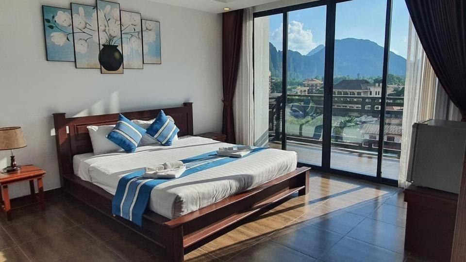 万荣VANG VIENG TOPVIEW HOTEL的一间卧室设有一张大床和一个大窗户