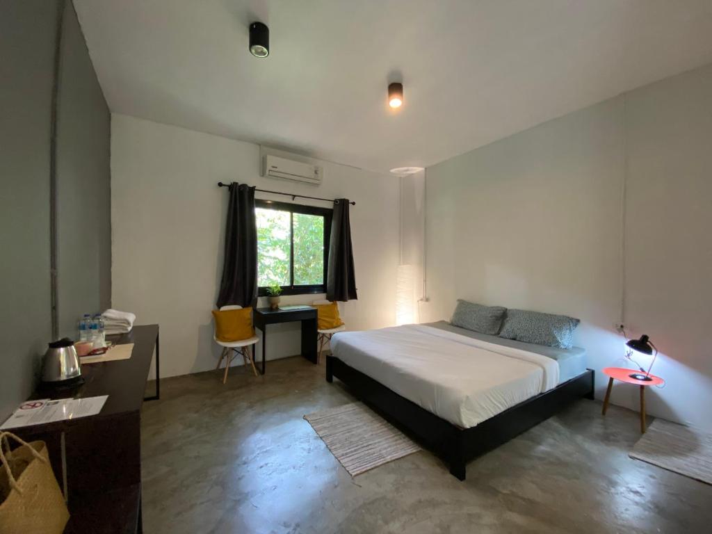董里诺克胡克旅舍的一间卧室配有一张床、一张书桌和一个窗户。