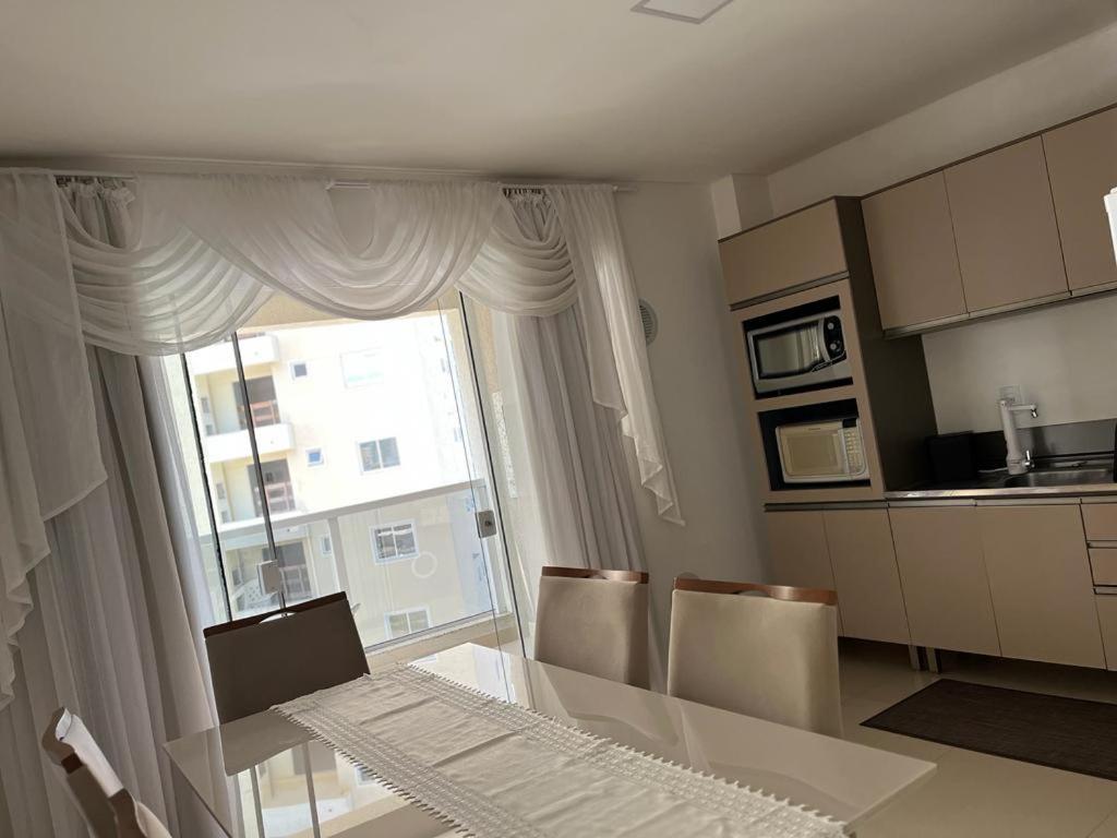 伊塔佩马Apartamento à 400m do mar的厨房配有桌椅和窗户。