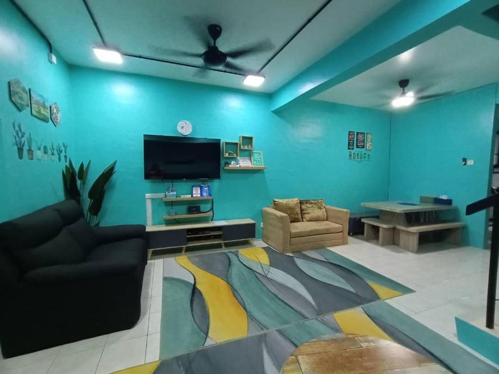 甲抛峇底The Handz House II with WIFI - For family or same gender only的客厅设有蓝色的墙壁和平面电视。