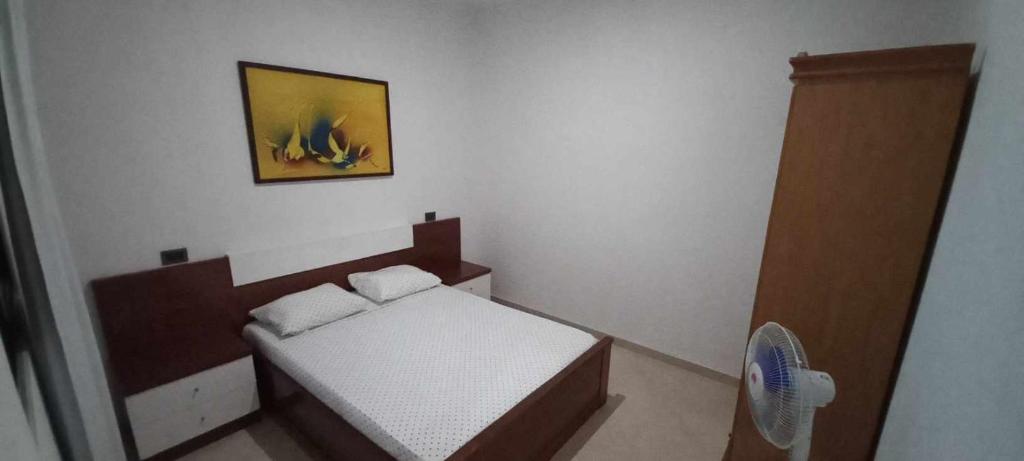 萨尔雷Apartamento Avenida的一间小卧室,配有一张床和墙上的照片