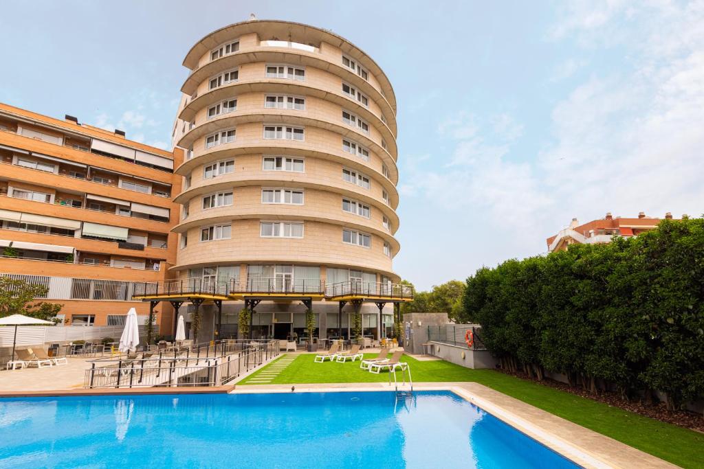 维拉塞加德索尔辛纳Ponient Vila Centric by PortAventura World的大楼前设有游泳池的酒店